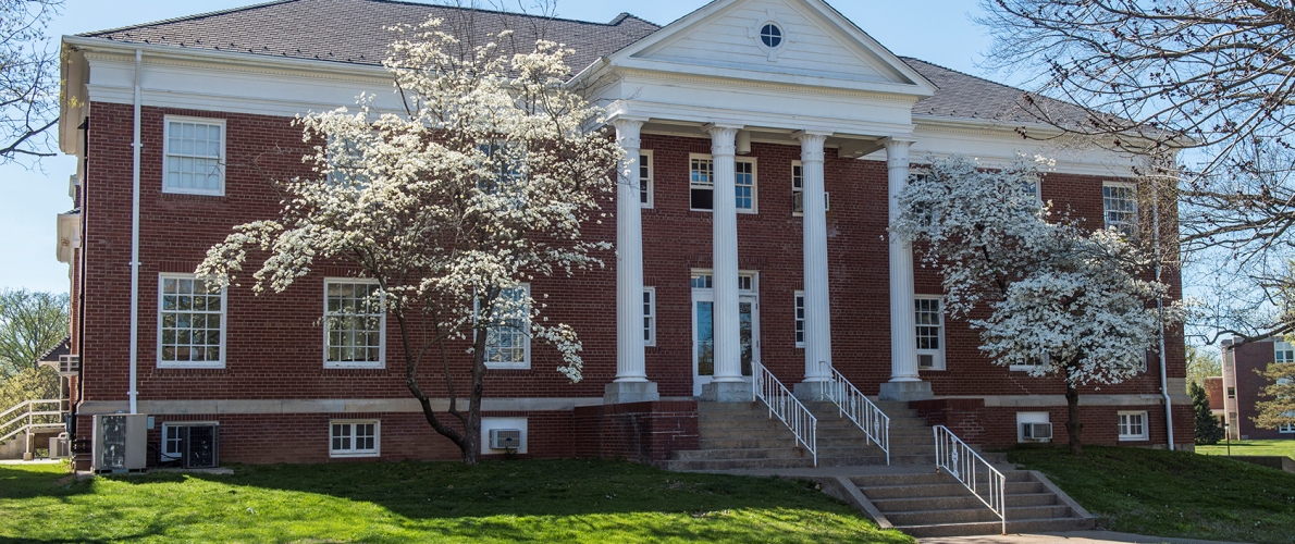 columned building surrounded by trees